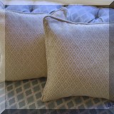 D056. Pair of 17” diamond pattern down pillows.